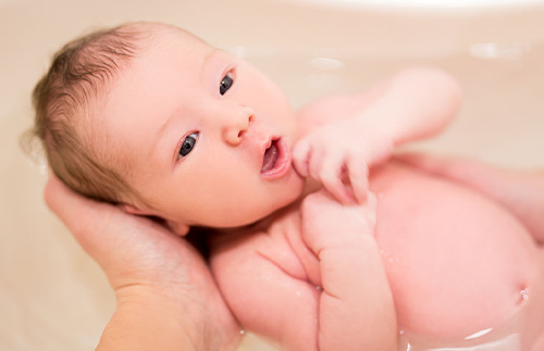 newborn baby getting a bath