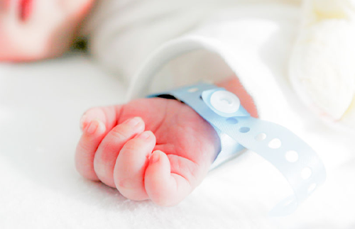 newborn's hand with hospital bracelet