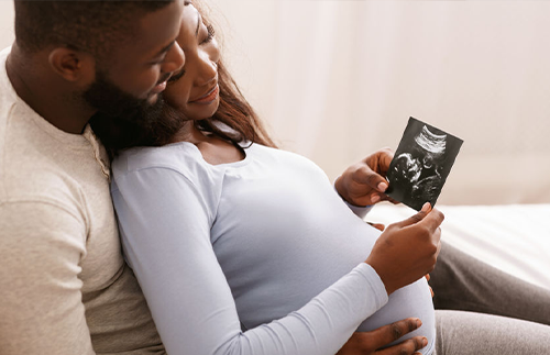 mother and father looking at ultrasound of baby