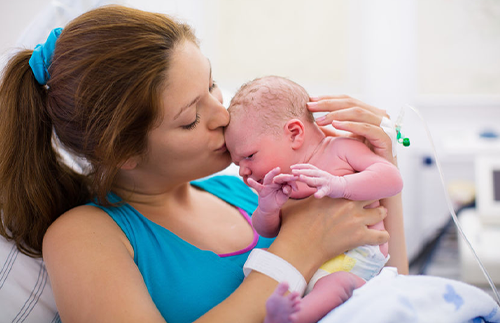 new mother kissing her newborn