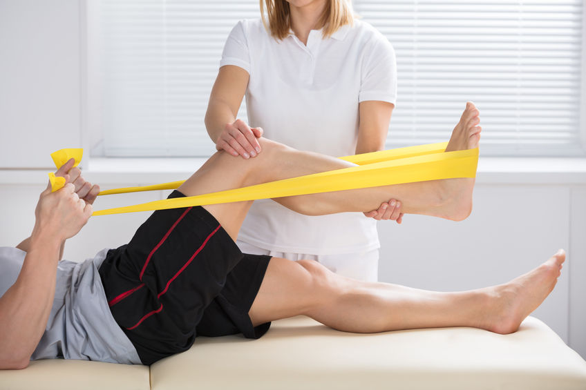 Physiotherapist Giving Treatment With Exercise Band