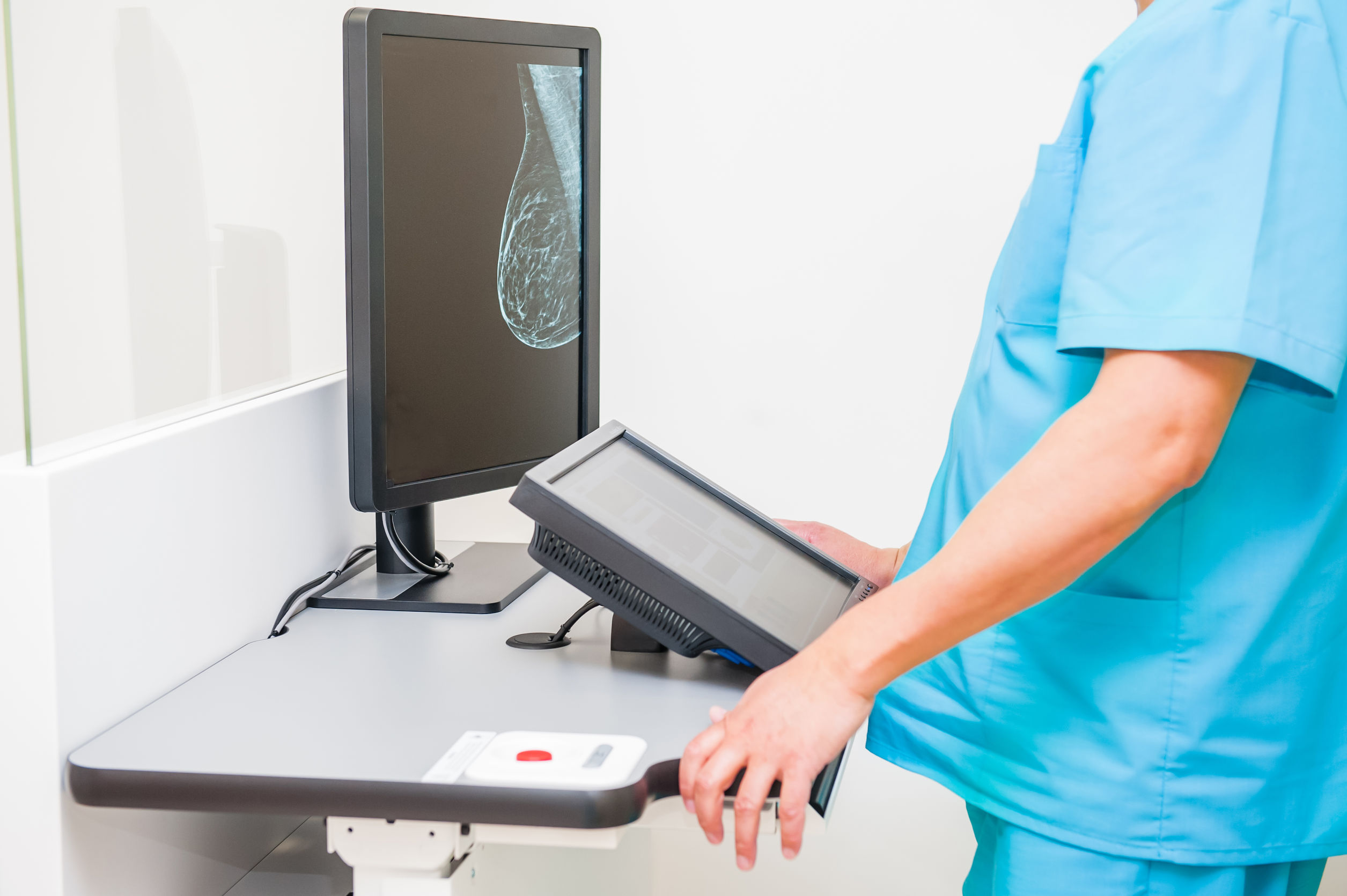 Doctor looking at mammogram snapshot of breasts of a female patient on the monitor. Selective focus