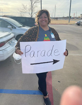 MTNRC employee holding "Parade" sign with arrow