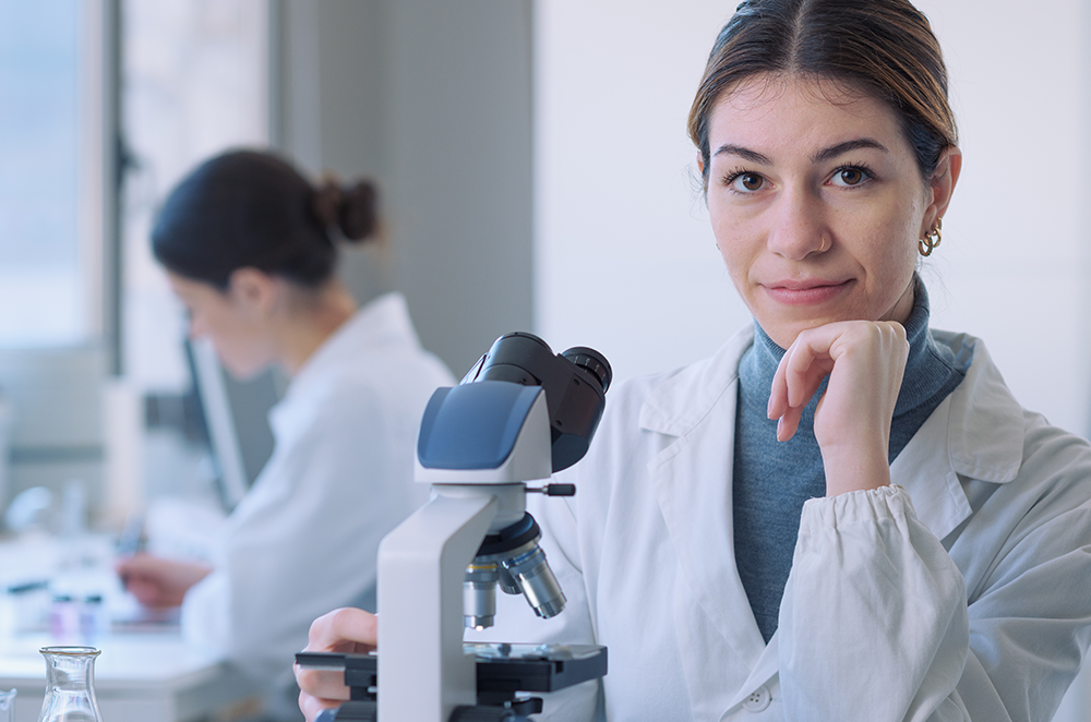 Female medical worker looking at microscope